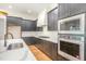Modern kitchen with stainless steel appliances, white countertops, and dark gray cabinets at 14020 Durant Rd, Raleigh, NC 27614
