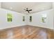Spacious main bedroom with hardwood floors, tray ceiling, and multiple windows at 14020 Durant Rd, Raleigh, NC 27614