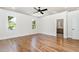 Main bedroom featuring hardwood floors, tray ceiling, large windows, and ensuite bathroom at 14020 Durant Rd, Raleigh, NC 27614