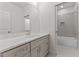 Bathroom with grey vanity, marble counters, large mirror and an attached tub/shower room with matching tile at 100 N Ridge View Way, Franklinton, NC 27525