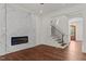 Open-concept living space with an electric fireplace, hardwood floors and stairway at 100 N Ridge View Way, Franklinton, NC 27525
