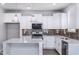 Modern kitchen featuring white cabinets, quartz countertops, and stylish light fixtures at 5828 Genesee Dr., Homesite 9, Durham, NC 27712