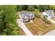 A high angle view of a home surrounded by lush trees with a long driveway leading up to the residence at 225 Whistlers Cv, Louisburg, NC 27549