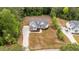 Aerial view of a house with a long driveway, manicured lawn, and surrounded by mature trees, emphasizing privacy at 225 Whistlers Cv, Louisburg, NC 27549