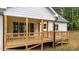A spacious wooden patio with views of the yard offers a perfect setting for outdoor relaxation and entertaining guests at 225 Whistlers Cv, Louisburg, NC 27549