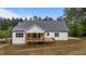 Exterior view of house with an outdoor porch and a dark grey roof surrounded by greenery at 225 Whistlers Cv, Louisburg, NC 27549