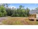 View of a large backyard that backs up to a wooded area featuring a wooden porch at 225 Whistlers Cv, Louisburg, NC 27549