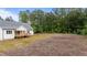 The backyard showcases a blend of lawn and wooded area, creating a harmonious transition from manicured to natural landscapes at 225 Whistlers Cv, Louisburg, NC 27549