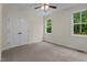 Neutral bedroom featuring carpeted floors, closet, and dual windows with beautiful outdoor view at 225 Whistlers Cv, Louisburg, NC 27549