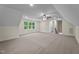 Large bonus room with carpet, natural light from windows, and stairs leading to another part of the home at 225 Whistlers Cv, Louisburg, NC 27549