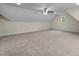 Spacious bonus room featuring carpet, a window, and sloped ceilings creating a cozy atmosphere at 225 Whistlers Cv, Louisburg, NC 27549