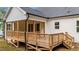 Beautiful wooden deck with a screened-in porch, steps to yard, and white siding of the house at 225 Whistlers Cv, Louisburg, NC 27549