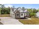 Stunning exterior view of home featuring white siding and a stone facade with a concrete driveway at 225 Whistlers Cv, Louisburg, NC 27549