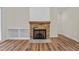 Cozy stone fireplace with built-in shelving and hardwood flooring, creating a warm ambiance at 225 Whistlers Cv, Louisburg, NC 27549