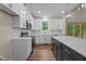 Modern kitchen featuring white cabinets, stainless steel appliances, and a dark central island at 225 Whistlers Cv, Louisburg, NC 27549