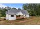 View of the home's rear featuring white siding and a charming wooden deck, offering a serene outdoor space at 225 Whistlers Cv, Louisburg, NC 27549