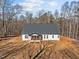Beautiful aerial view of a white farmhouse with a dark roof and lush surroundings at 2817 Silk Hope Gum Springs Rd, Pittsboro, NC 27312