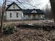 New construction home exterior with a white facade, black roof, and inviting front porch nestled among trees at 2817 Silk Hope Gum Springs Rd, Pittsboro, NC 27312