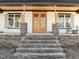 Inviting front porch with stone pillars and a double door entry showcasing the home's charm at 2817 Silk Hope Gum Springs Rd, Pittsboro, NC 27312