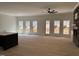 Spacious living room with a stone fireplace, many windows, and beautiful wood floors at 2817 Silk Hope Gum Springs Rd, Pittsboro, NC 27312