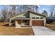 Modern house with green siding, brown garage door, and a landscaped yard at 5300 Pulley Town Rd, Zebulon, NC 27597