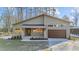 Modern house exterior with light green siding, brown garage door, and landscaped lawn at 5300 Pulley Town Rd, Zebulon, NC 27597