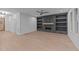 Open-concept living room with modern fireplace, custom shelving, and light hardwood floors at 5300 Pulley Town Rd, Zebulon, NC 27597