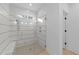Modern tiled shower featuring glass door, bench, and updated shower fixtures at 5300 Pulley Town Rd, Zebulon, NC 27597