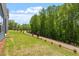 The backyard features well-manicured grass with beautiful, mature trees at 119 Augusta Pond Way # 147, Raleigh, NC 27603