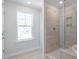 Bright bathroom featuring a glass shower and a large window overlooking the outdoors at 119 Augusta Pond Way # 147, Raleigh, NC 27603