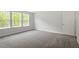 Large bedroom with plush carpeting, neutral paint and bright light from a large window at 119 Augusta Pond Way # 147, Raleigh, NC 27603