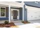 Inviting home entrance with a classic black door, white trim, and a two-car garage to the right at 119 Augusta Pond Way # 147, Raleigh, NC 27603