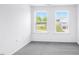 Bright bedroom with two windows overlooking the outdoors and neutral carpet flooring at 289 Hank Way, Angier, NC 27501
