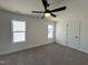 Simple bedroom with gray carpet, ceiling fan, and two windows at 149 Greenview St, Clayton, NC 27520