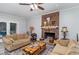 Inviting living room with a brick fireplace, laminate floors, and a ceiling fan at 203 Willow Ct, Angier, NC 27501