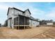 View of the home's exterior with gray siding and a screened-in back porch under a blue sky at 100 Firefly Ln, Louisburg, NC 27549