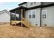 An eye-level exterior shot of a home's screened in porch with a wooden staircase and gray siding at 100 Firefly Ln, Louisburg, NC 27549