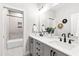 Modern bathroom featuring a dual sink vanity, large mirror, and tub shower combo at 100 Firefly Ln, Louisburg, NC 27549