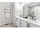 Bright bathroom featuring a double vanity with matte black fixtures and a large mirror and walk-in shower at 100 Firefly Ln, Louisburg, NC 27549
