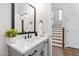 Well-lit powder bathroom with gray cabinets, modern fixtures, and a stylish mirror at 100 Firefly Ln, Louisburg, NC 27549