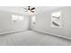 Light-filled bedroom with gray carpet, three windows and a modern ceiling fan at 100 Firefly Ln, Louisburg, NC 27549