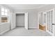 Bedroom with gray carpet, window, open closet with door, and view to another room through french doors at 100 Firefly Ln, Louisburg, NC 27549