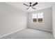 Empty bedroom featuring gray carpet, a ceiling fan, and a large window overlooking the yard at 100 Firefly Ln, Louisburg, NC 27549