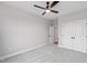 Empty bedroom with gray carpet, ceiling fan, closet doors and view of open door to a hallway at 100 Firefly Ln, Louisburg, NC 27549