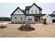 Two-story farmhouse with gray siding, a covered porch, and a landscaped yard at 100 Firefly Ln, Louisburg, NC 27549