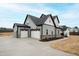 Wide shot of a new construction home, showing attached three-car garage and landscaping at 100 Firefly Ln, Louisburg, NC 27549