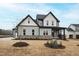 New construction two-story home with gray siding, black trim, and professionally landscaped front yard at 100 Firefly Ln, Louisburg, NC 27549