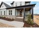 Covered front porch with stained wood door, brick steps, and black trim at 100 Firefly Ln, Louisburg, NC 27549