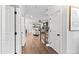 Hallway featuring hardwood floors, white trim, and views of the stairs and living room at 100 Firefly Ln, Louisburg, NC 27549