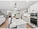 Bright, open kitchen featuring a large island, stainless steel appliances, and hardwood floors at 100 Firefly Ln, Louisburg, NC 27549